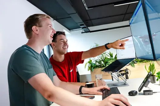 Twee IT-specialisten werken samen achter de computer