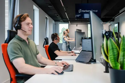 Supportmedewerkers helpen klanten via headset en computer