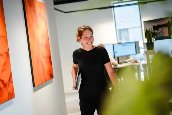 Medewerker van Harbers Group loopt door een gang met laptop – illustratie van mobiel werken, moderne IT-support en veilige digitale werkplekken.