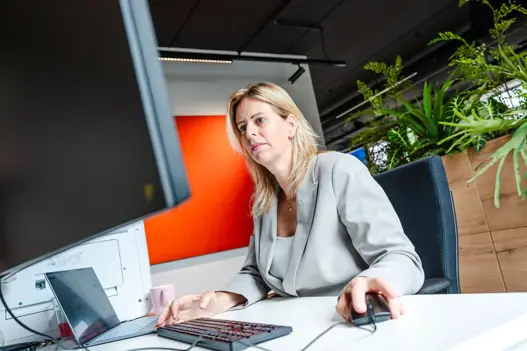 Supportmedewerkster met focus op het scherm, klaar om hulp te bieden