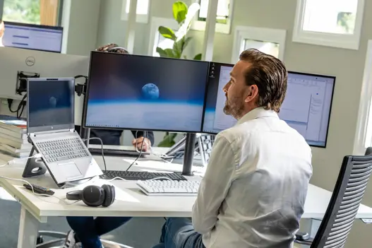 IT-consultant achter beeldscherm bezig met ontwikkeling en klaar om klanten te ondersteunen 
