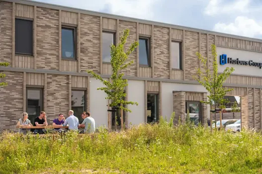 IT-specialist werkt geconcentreerd achter computer met programmeercode op het scherm, symbool voor technische expertise en softwareontwikkeling.