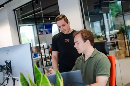 IT-specialisten in overleg, multitaskend met computer en telefoo