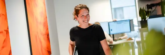 Medewerkster loopt met laptop door de gang van Harbers Group
