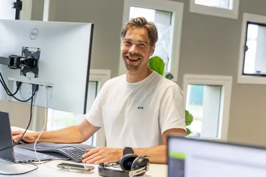 IT-expert van Harbers Group met een vriendelijke glimlach achter de computer